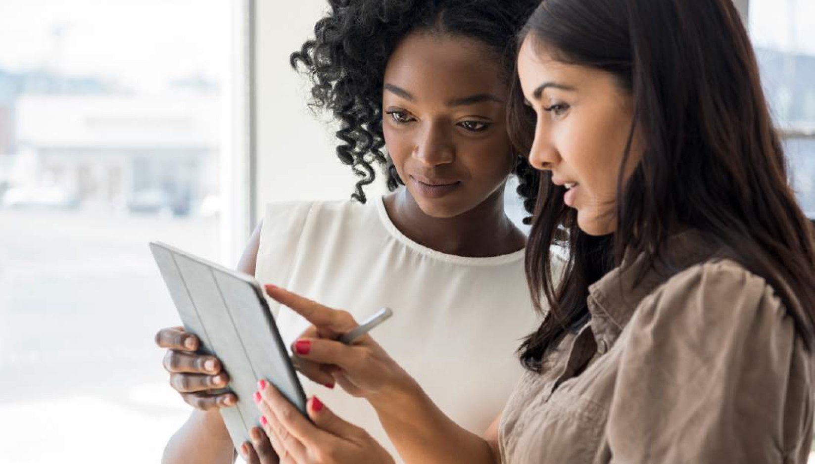 Two women looking at an iPad photograph